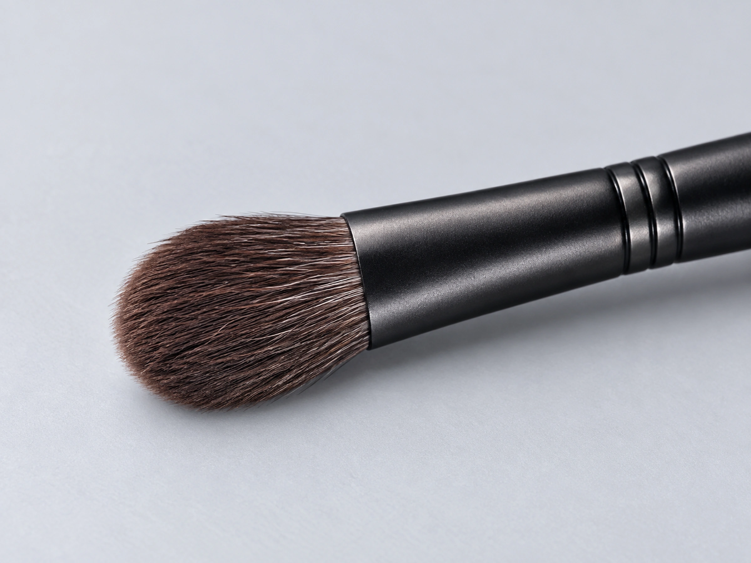B021 full rounded dark brown grey-squirrel eye-brush head in an oblique side view