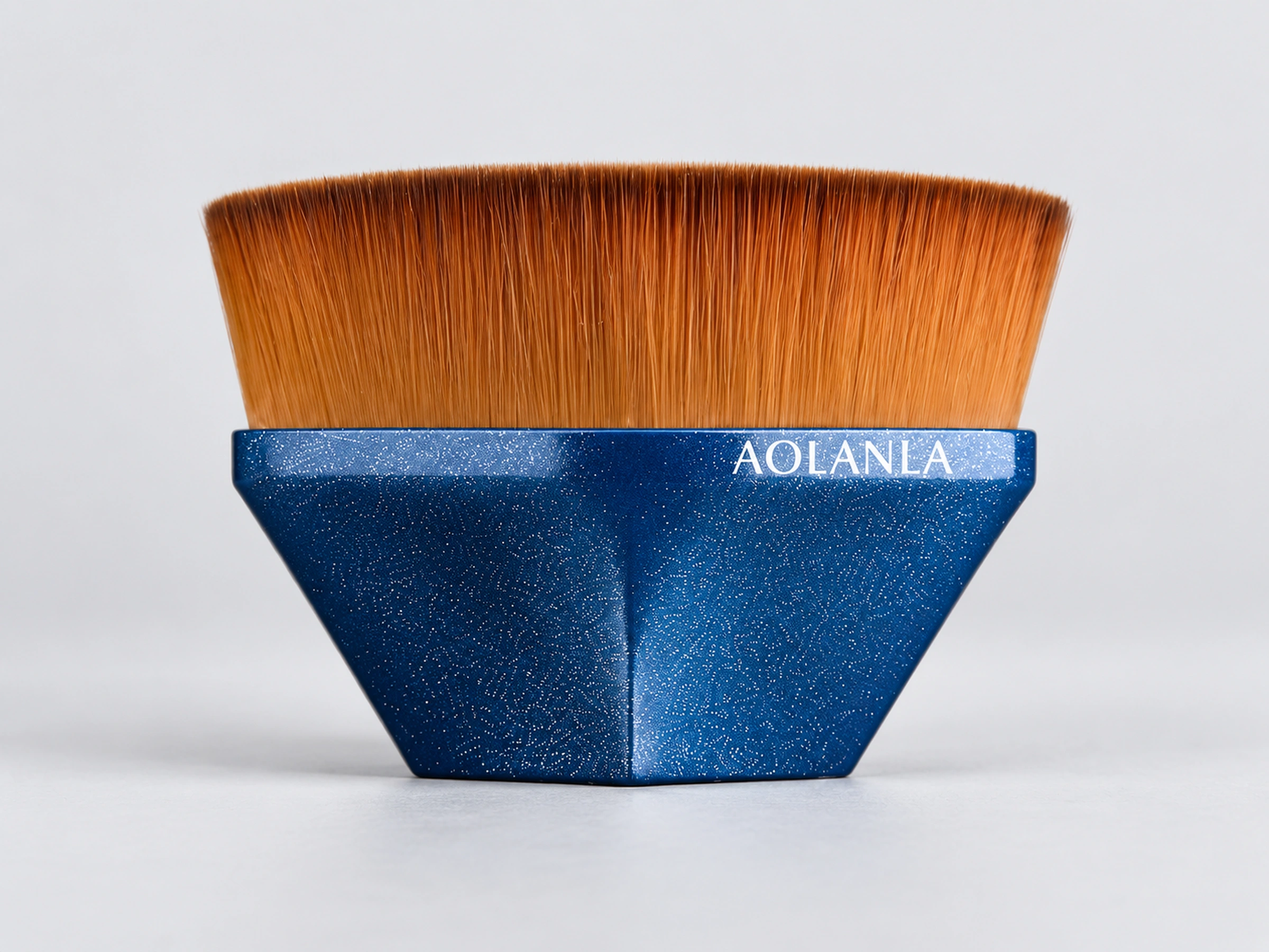 The included No.55 short faceted blue foundation brush with its dense golden synthetic working surface
