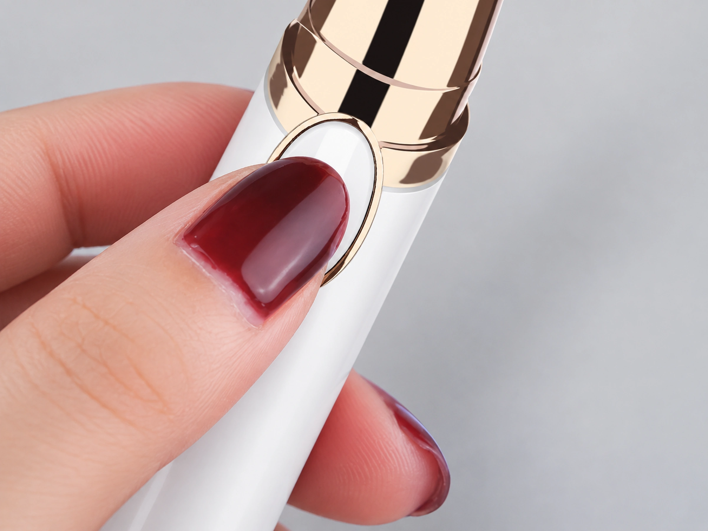 Original white trimmer oval slide switch operated gently by a burgundy-nailed thumb