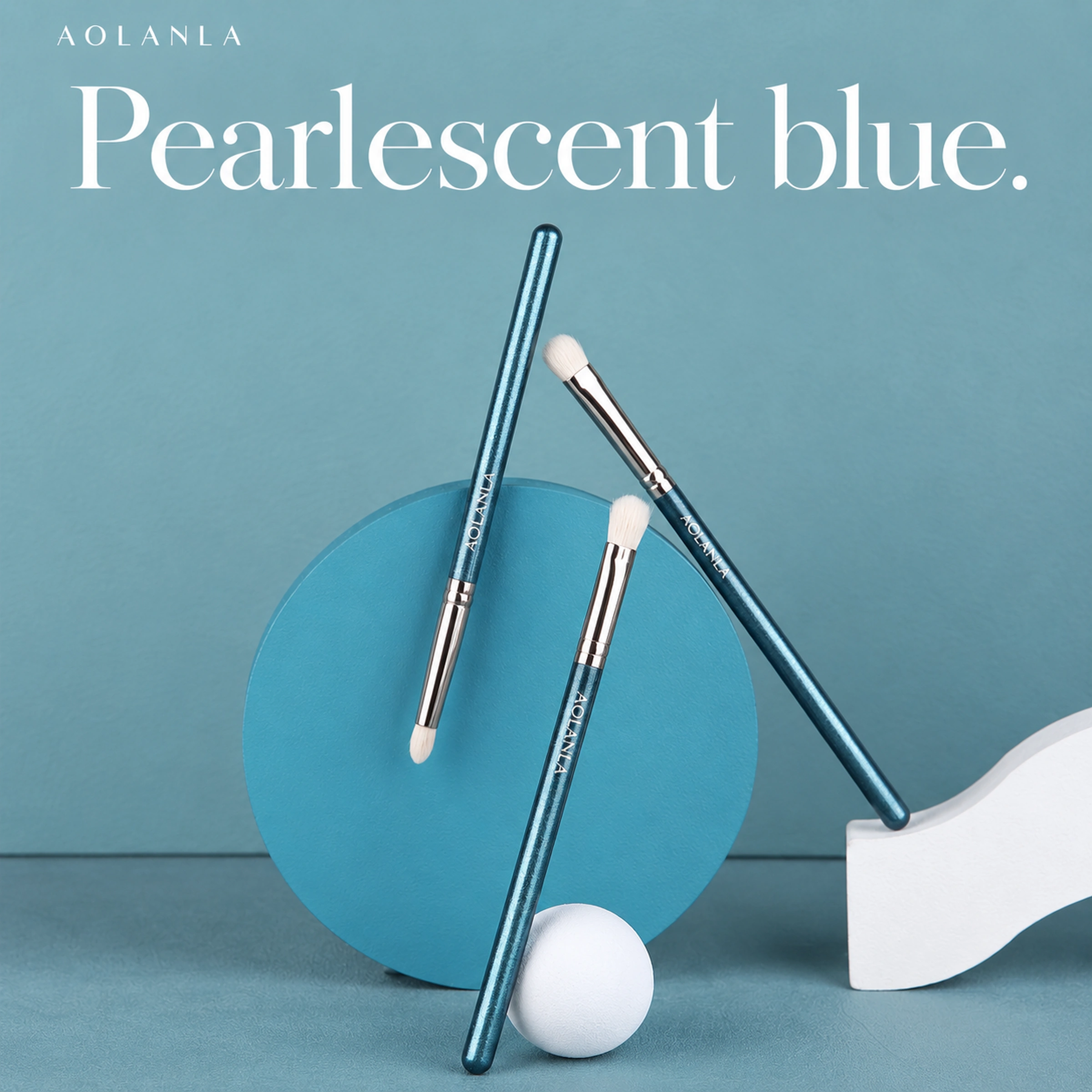 Three pearlescent blue brushes in a cool-blue studio still life