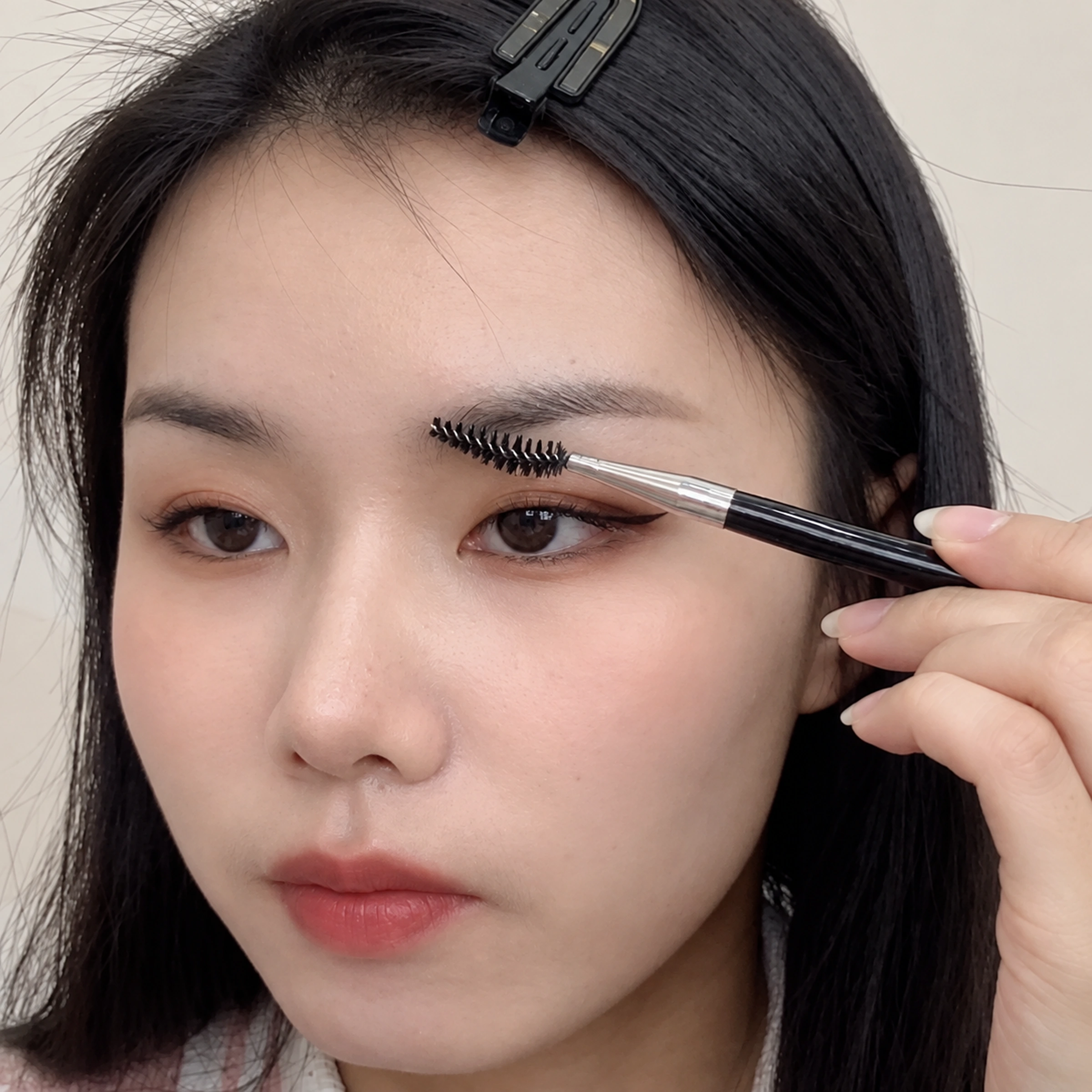 20 black-handled spoolie grooming an eyebrow