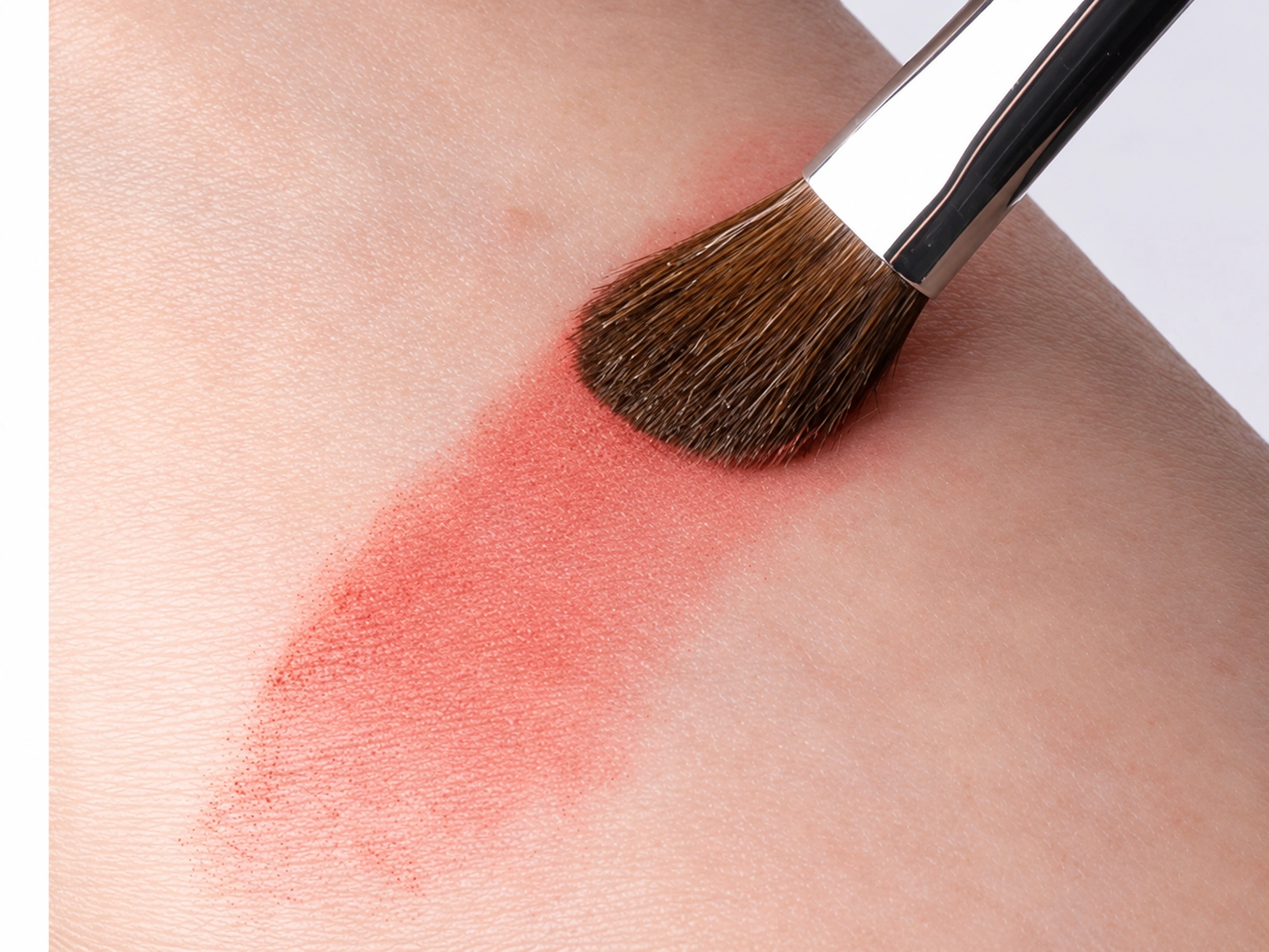 No.13 brush in gentle contact with a powder swatch on an actual wrist