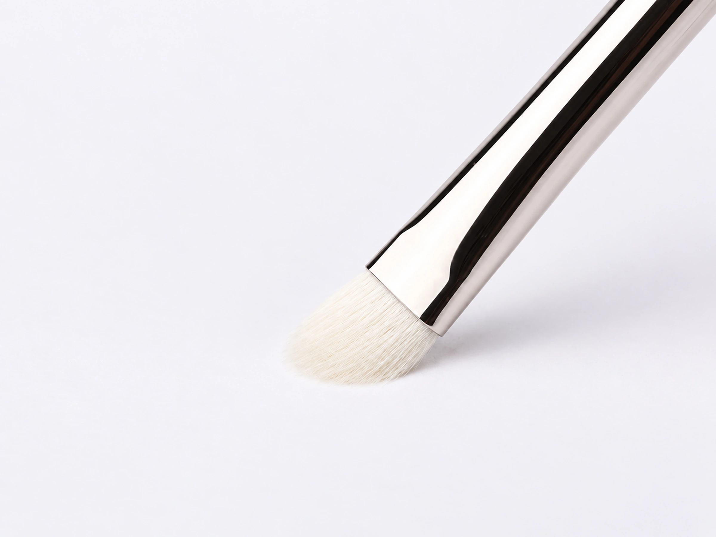 Actual No.239 white wool head gently flexing against a pale surface