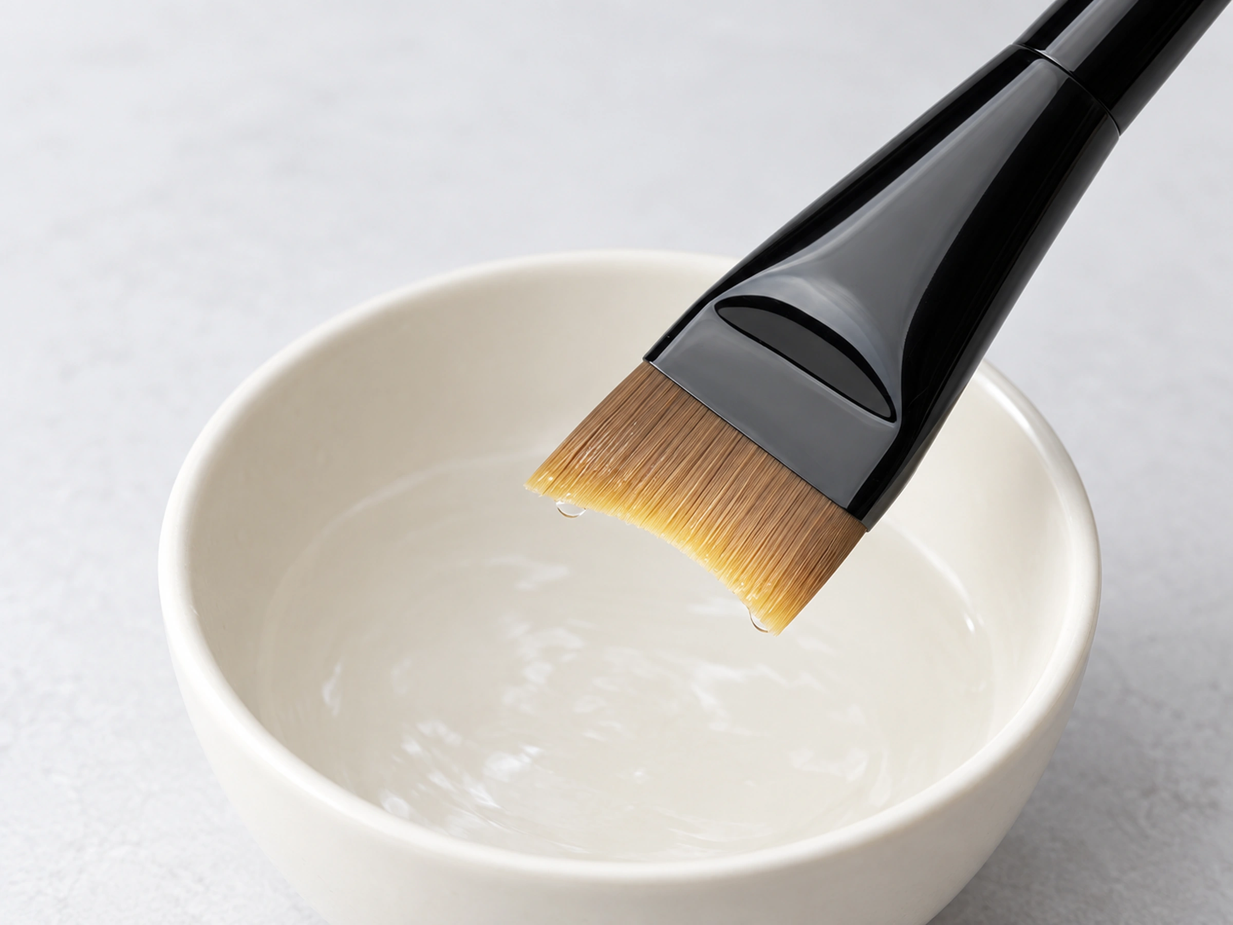 Original F19 fishtail brush rinsed above a pale cleaning bowl