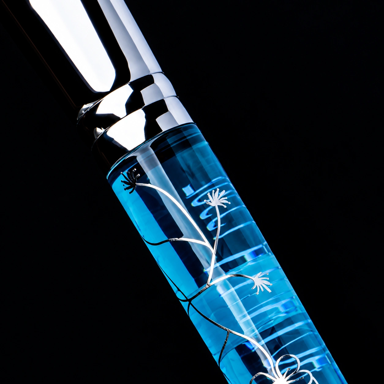 Close construction detail of the polished silver-tone ferrule meeting a transparent ice-blue acrylic handle with silver sakura decoration