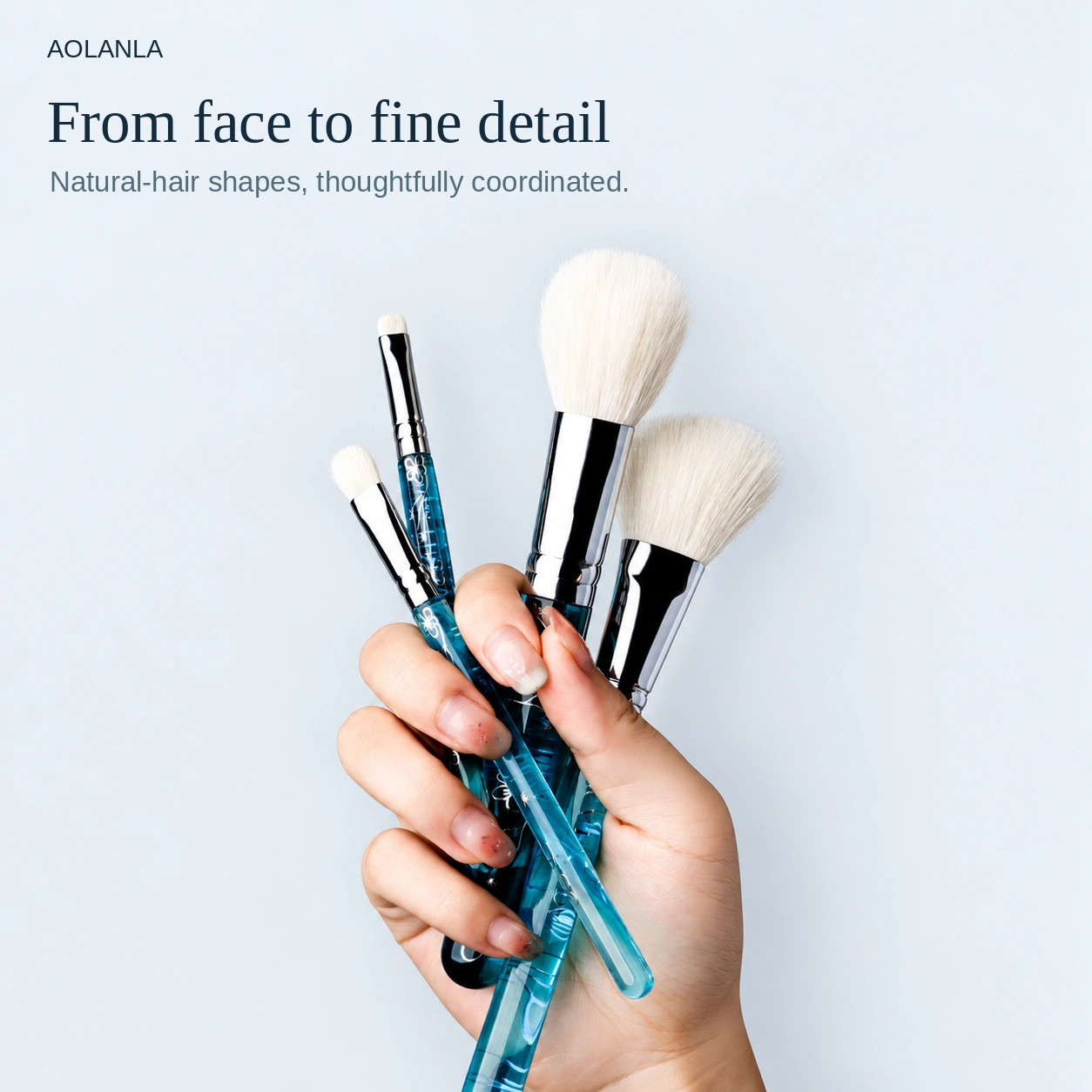 Four actual brush shapes held in one hand, showing natural-hair face and eye tools