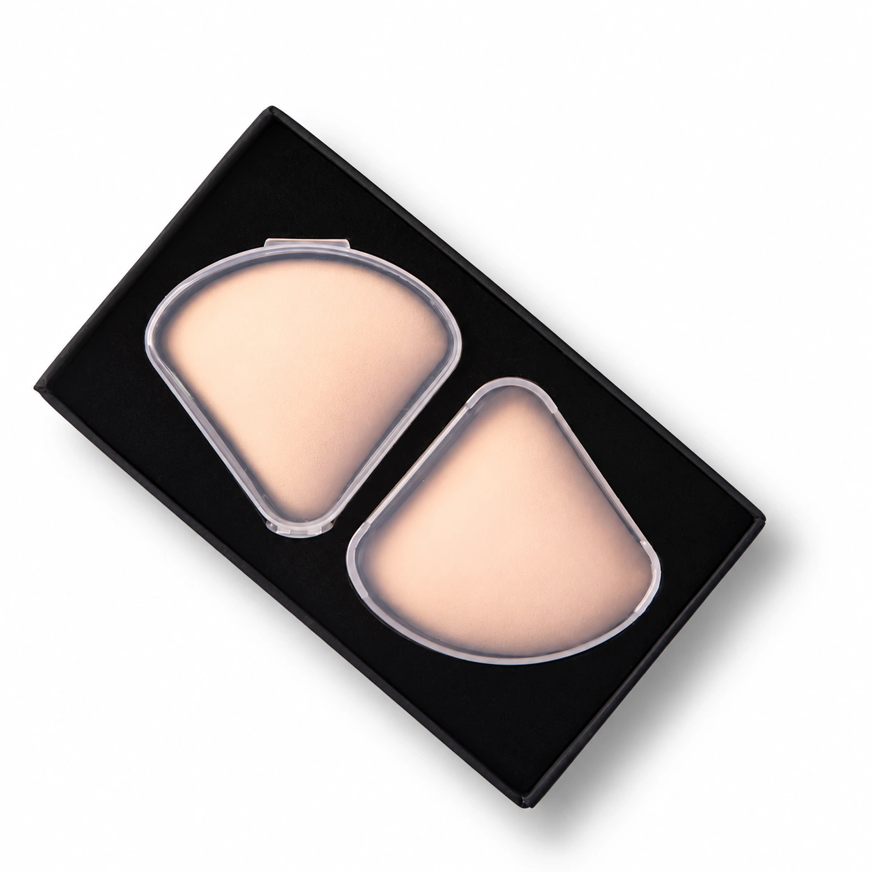 Two triangle puffs in individual clear cases in a black presentation tray