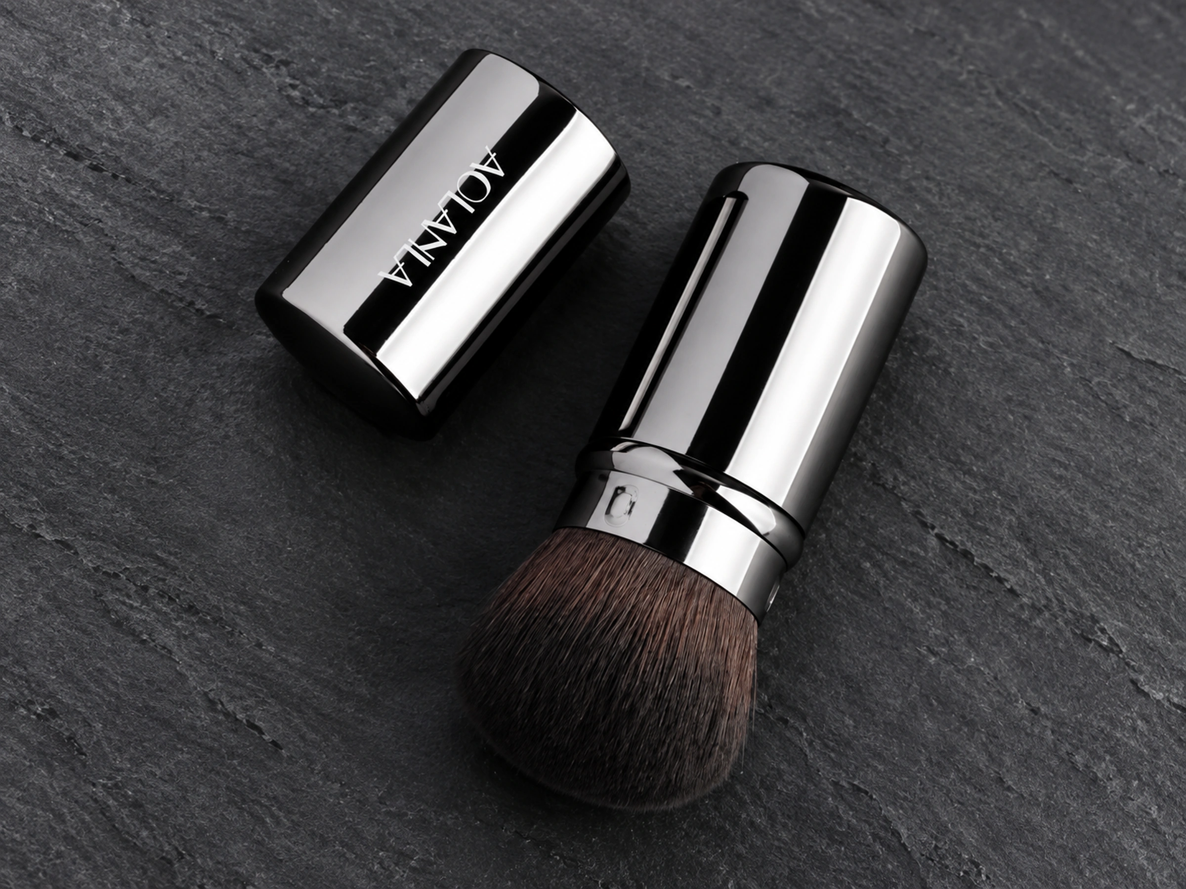 One original retractable powder brush open with its detached cylindrical cap