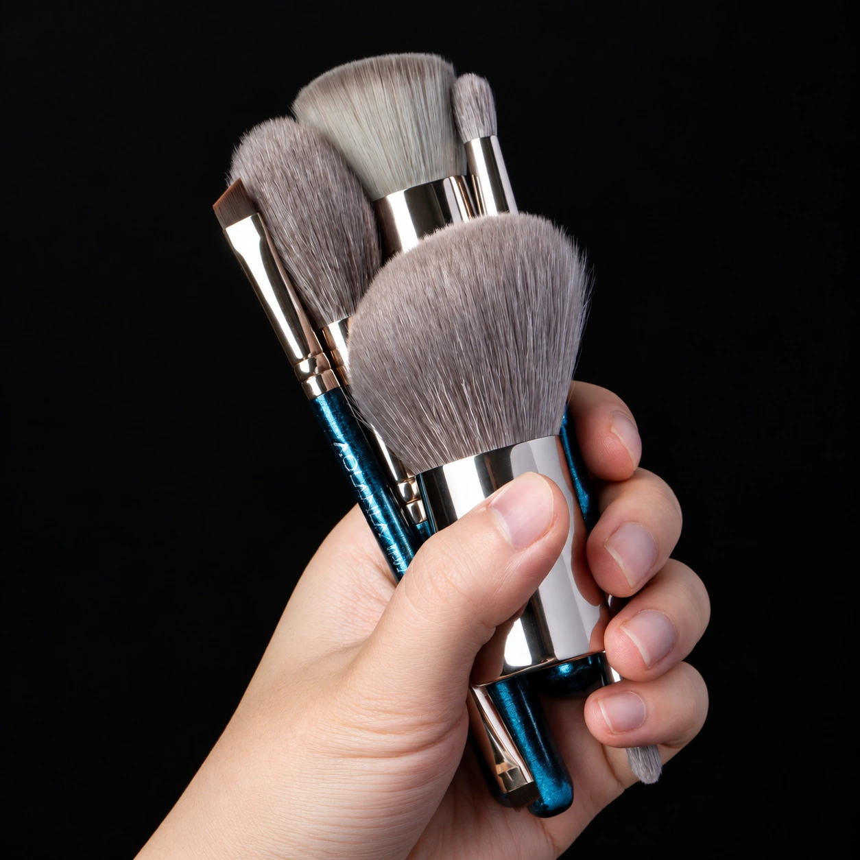 Five compact travel brushes held in one hand