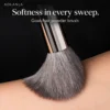 Grey goat-hair powder brush sweeping skin