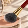 Vermilion Gold brush sweeping across pressed powder