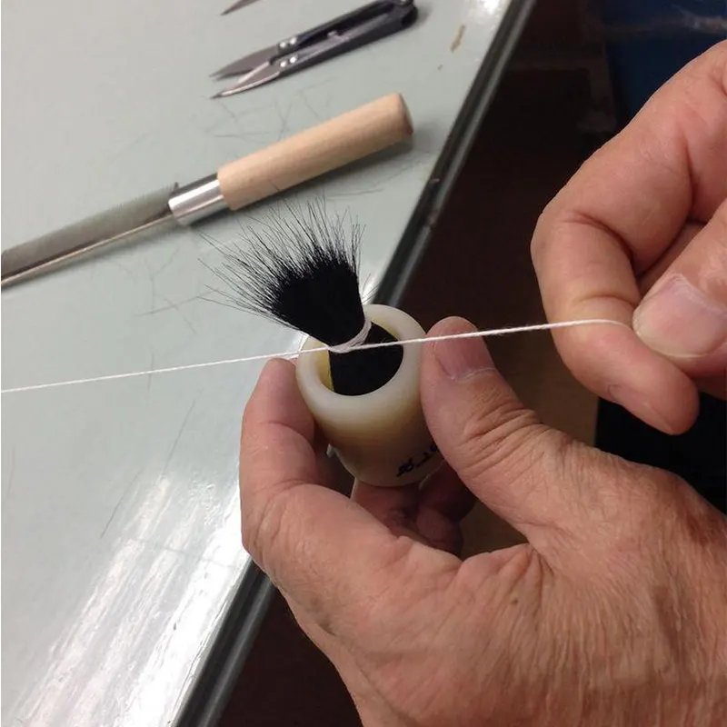 Brush head being shaped by hand during makeup brush production