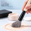 Flower & Bird natural-hair brush picking up loose powder in a light layer