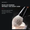 Close view of the AOLANLA powder brush picking up loose powder for a soft diffused finish
