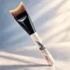 AOLANLA fishtail foundation brush showing its distinctive concave working edge